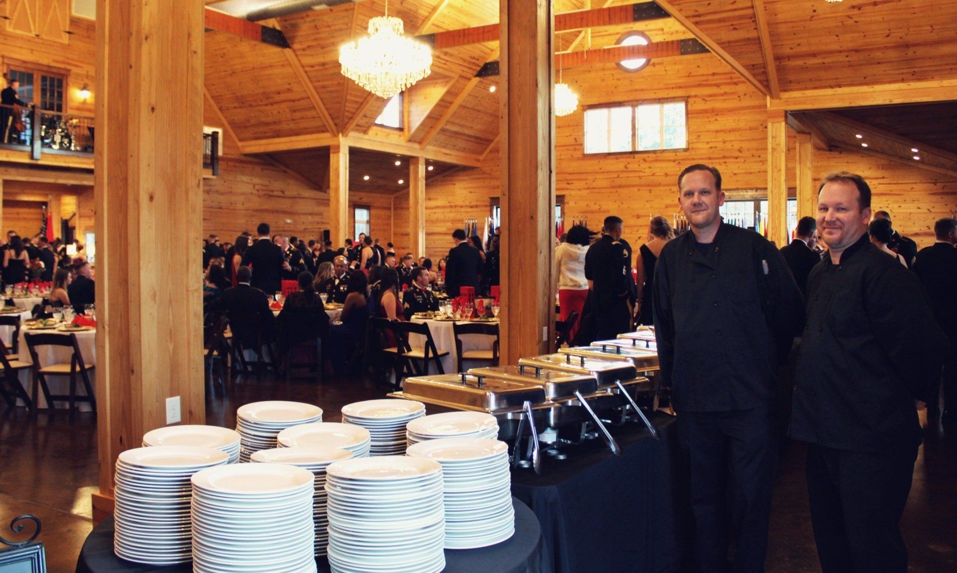 2 male caterers standing behind a buffet table at the Military Balls venue