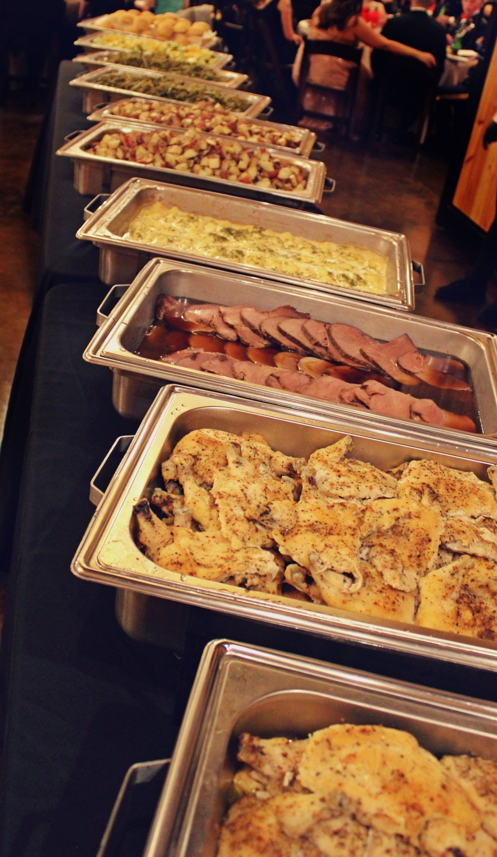 buffet pans filled with food line up on a buffet table