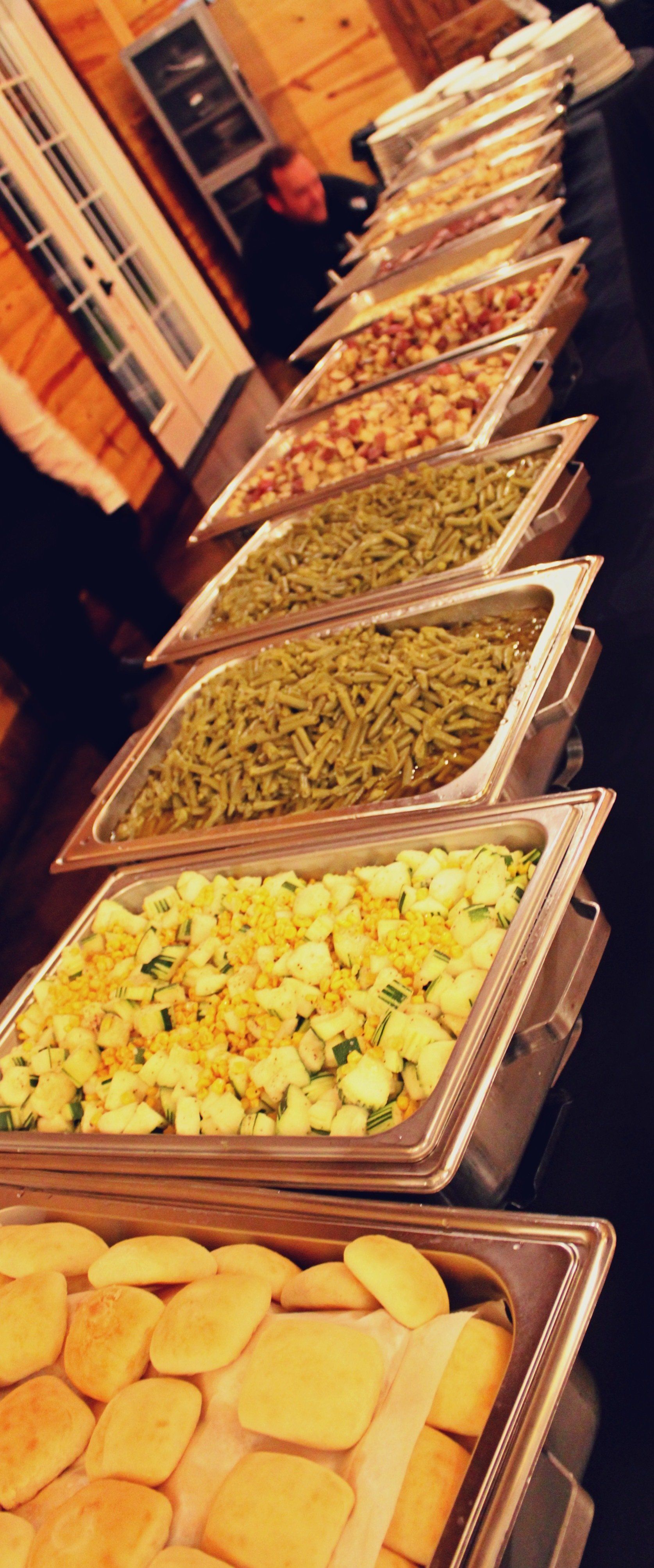 buffet pans filled with food lined up on buffet table