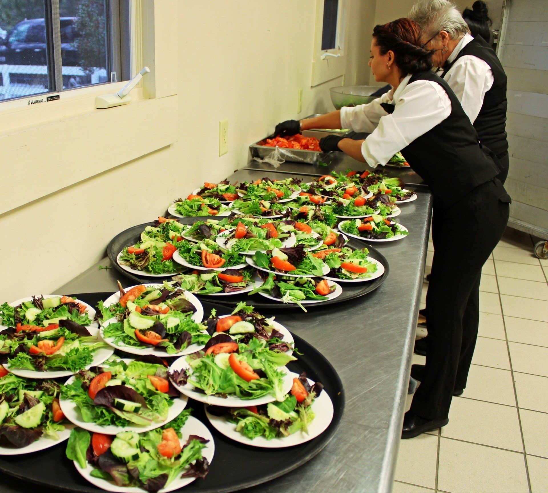 caterers setting up food in kitchen