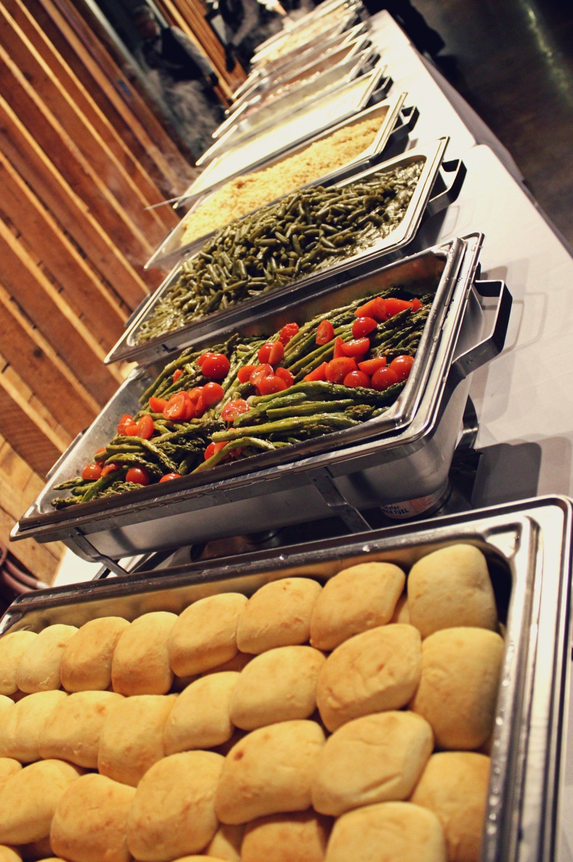 buffet pans filled with food lined up on buffet table