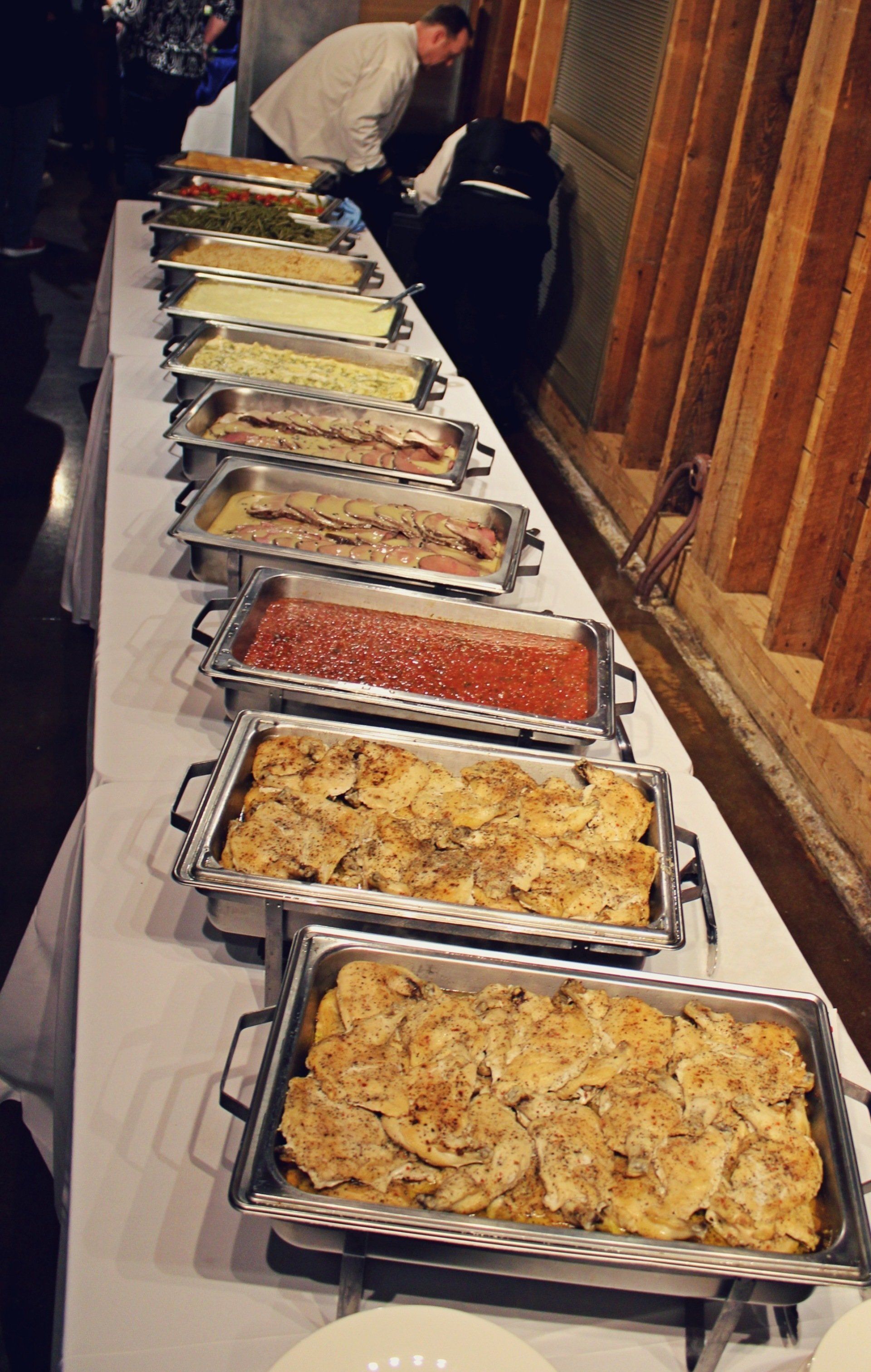 buffet pans of food lined up on buffet table
