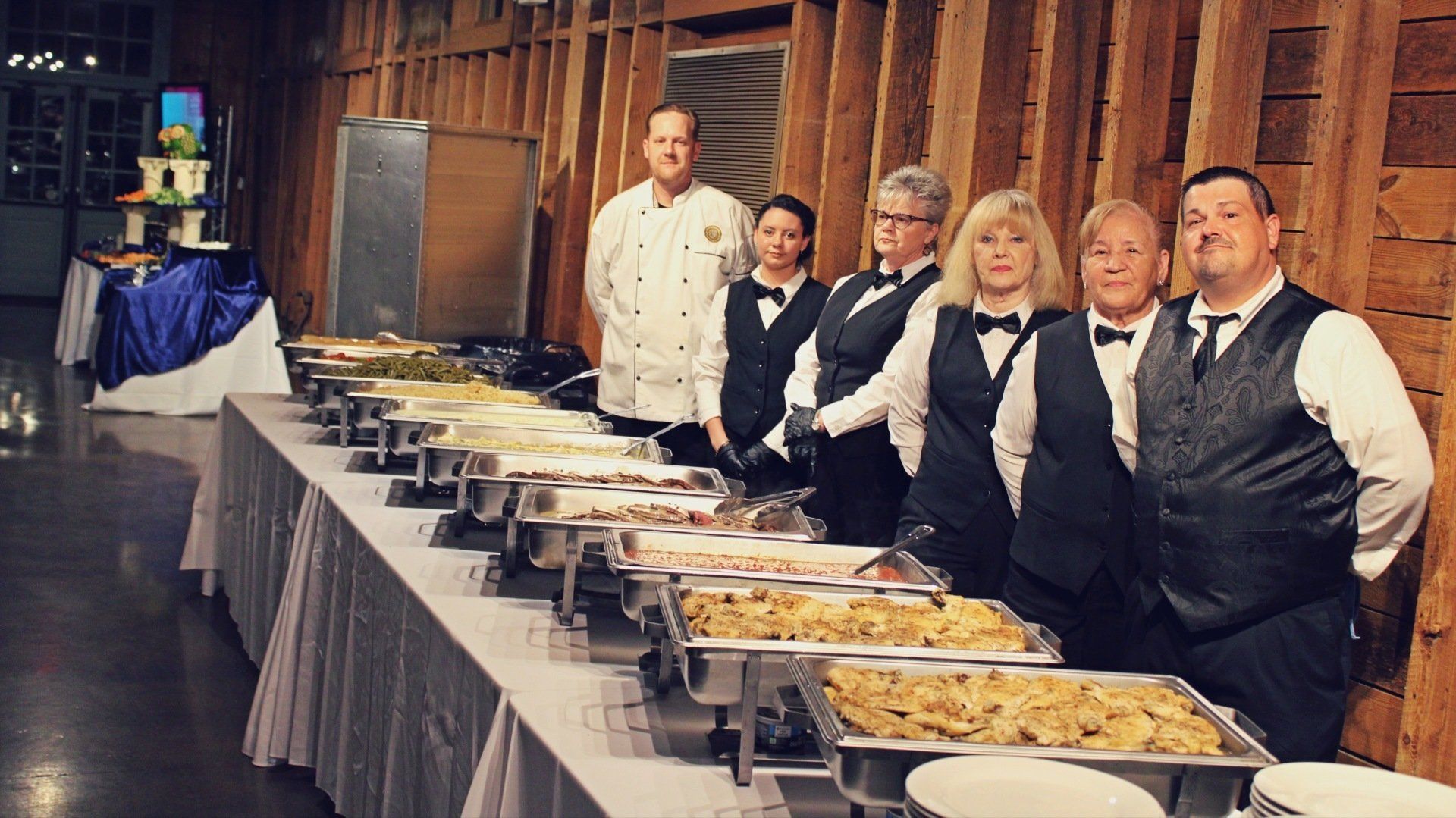 group of caterers standing behind a buffet table