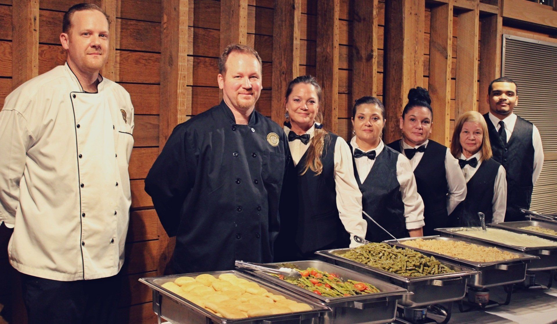 group of caterers standing behind a buffet table