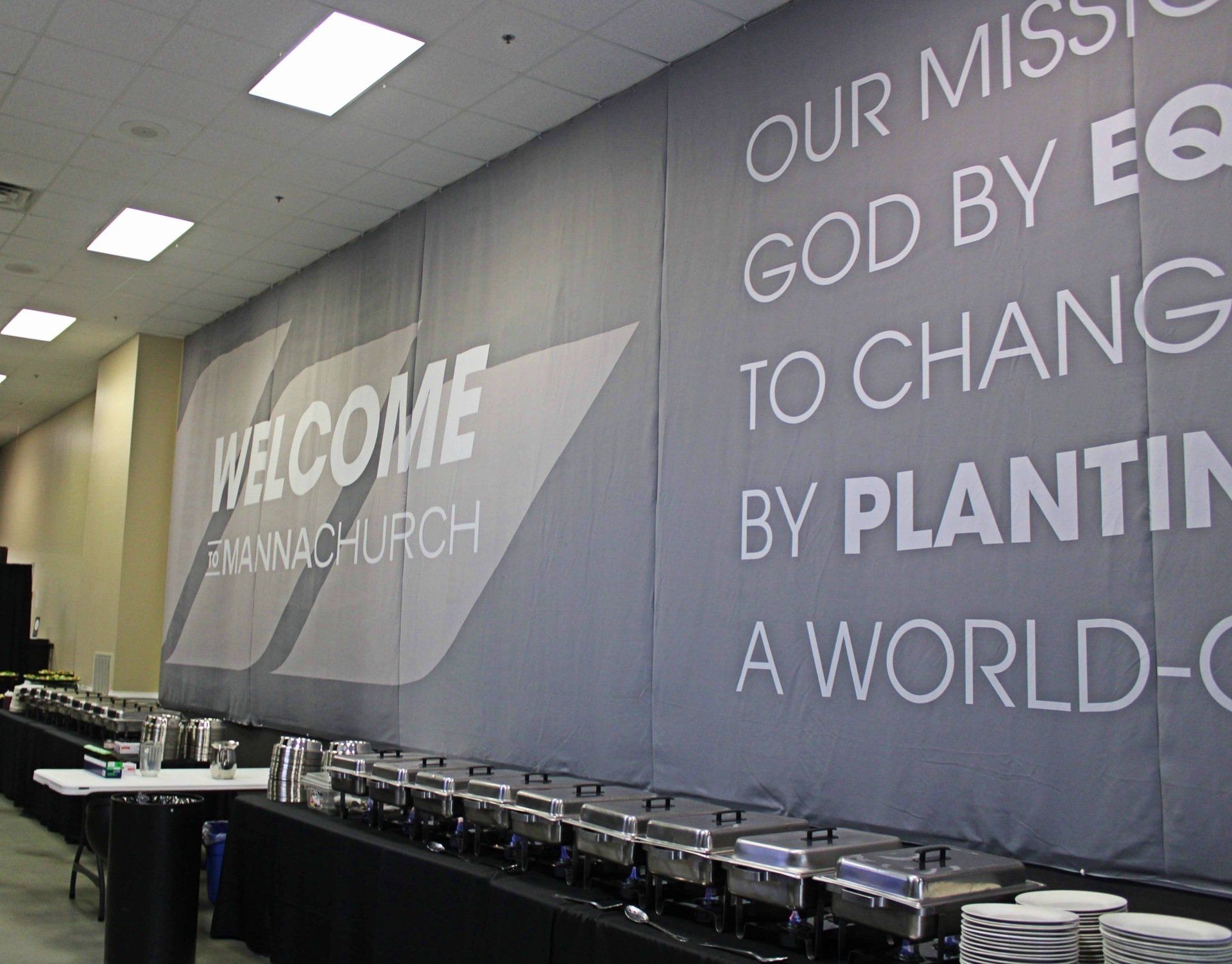 Manna Church Welcome Sign behind long buffet table