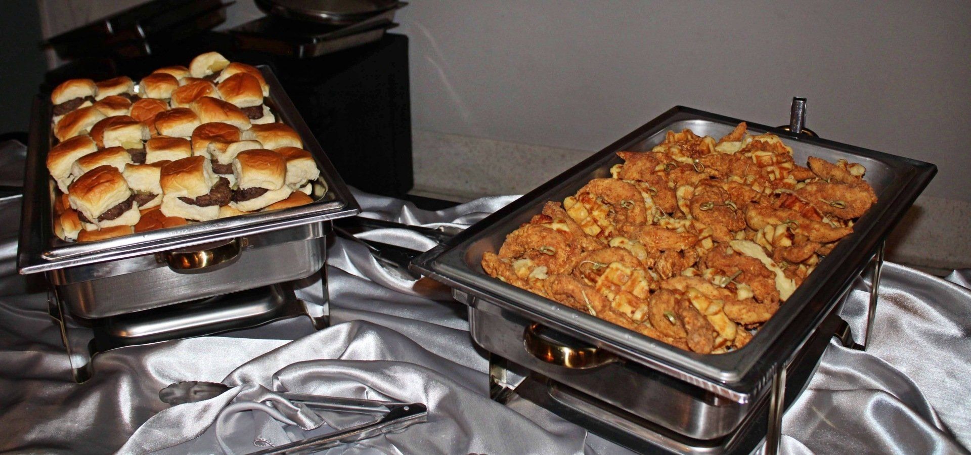 buffet pans filled with fried chicken skewers and sliders
