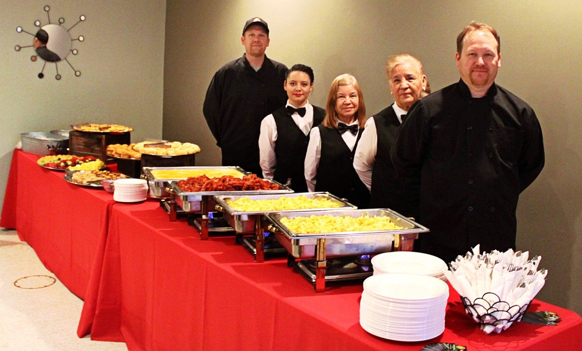 group of caterers standing behind a breakfast buffet