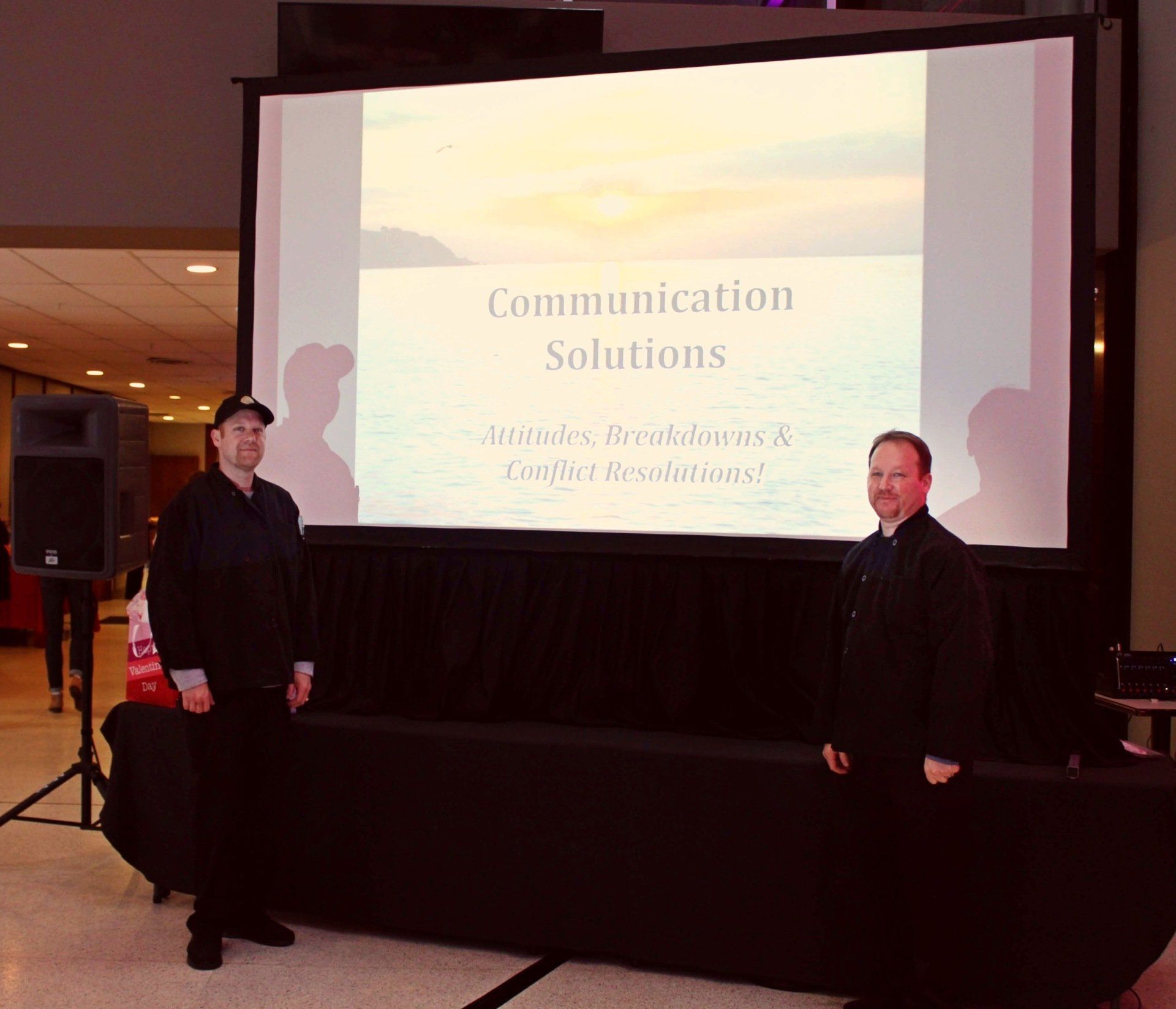 2 caterers standing in front of a presentation screen