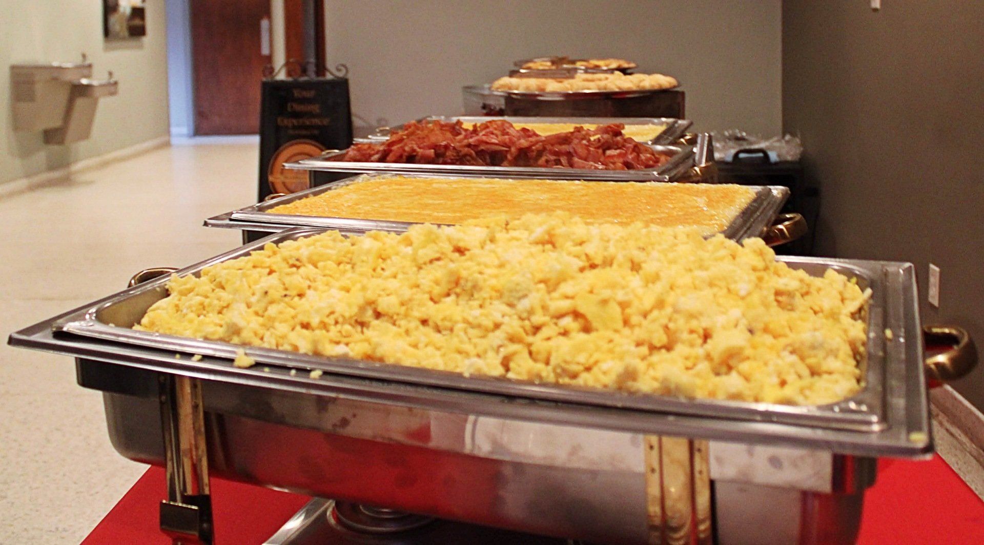 buffet pans lined up and filled with breakfast food