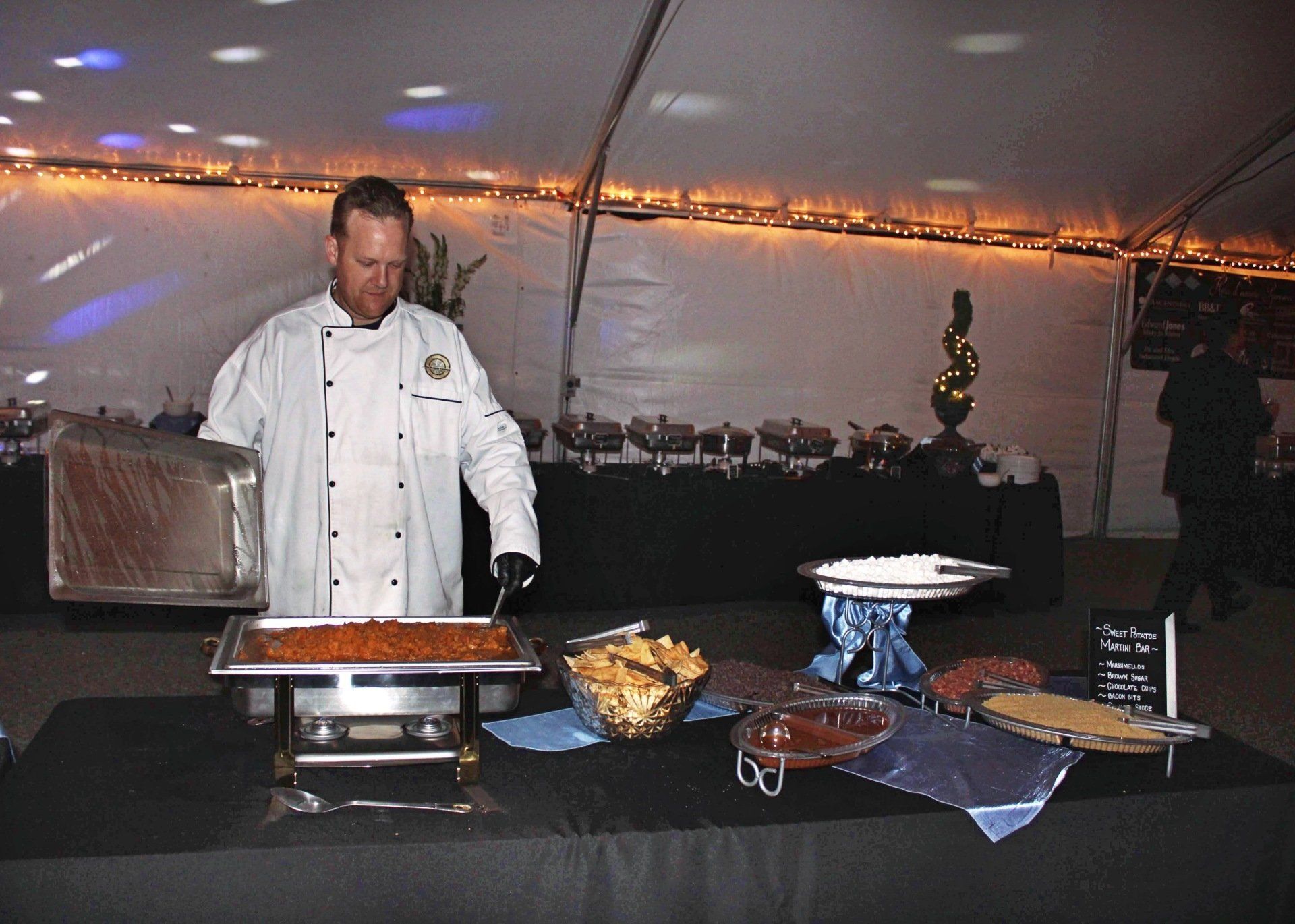 male caterer serving from a buffet pan
