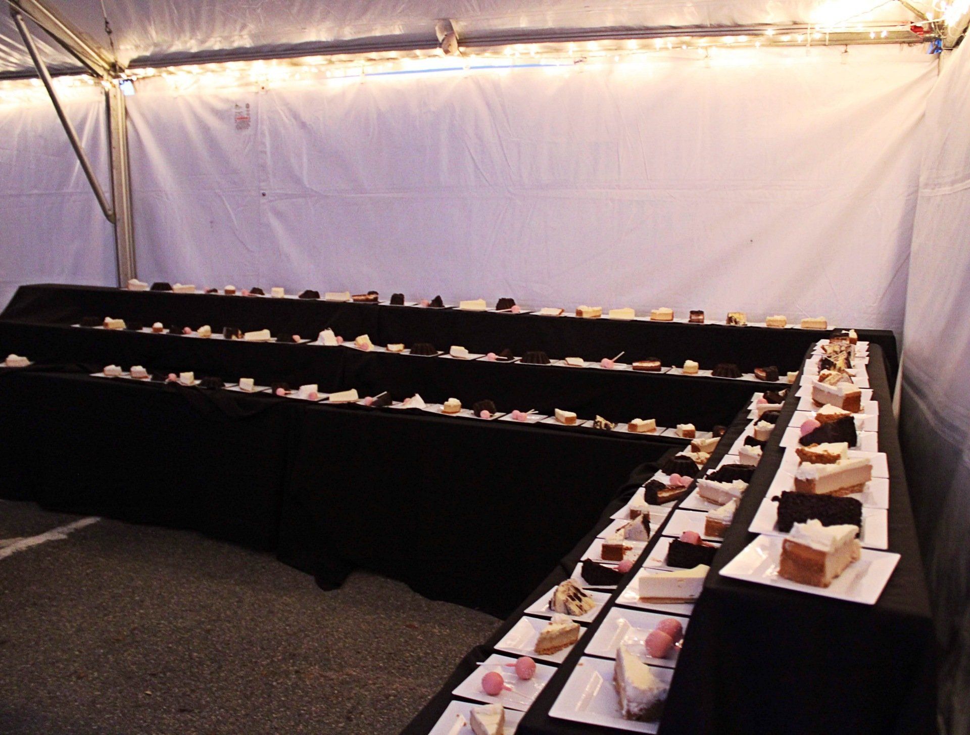 3 tiered long dessert table filled with plated assorted desserts