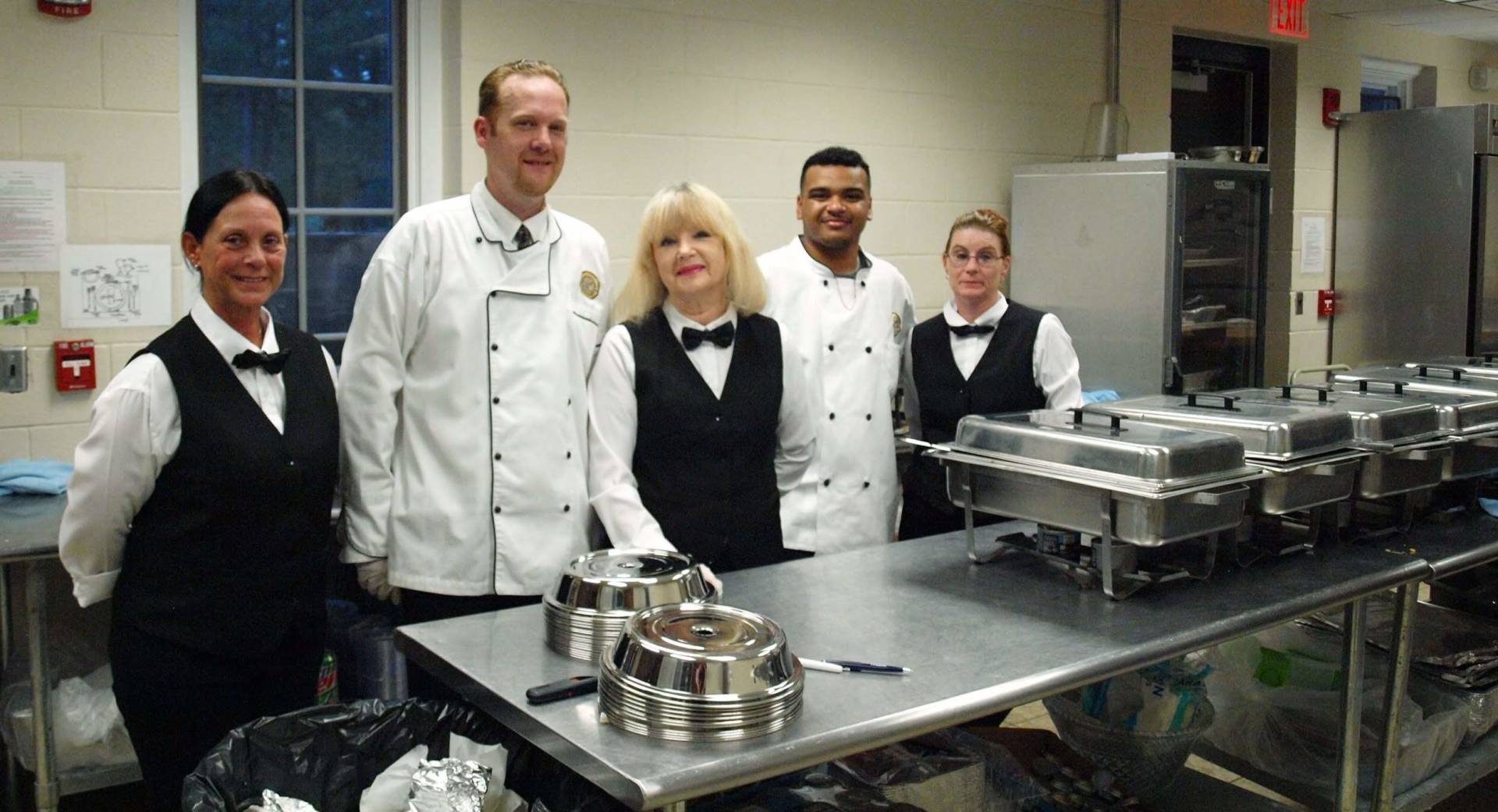 a group of caterers standing in kitchen