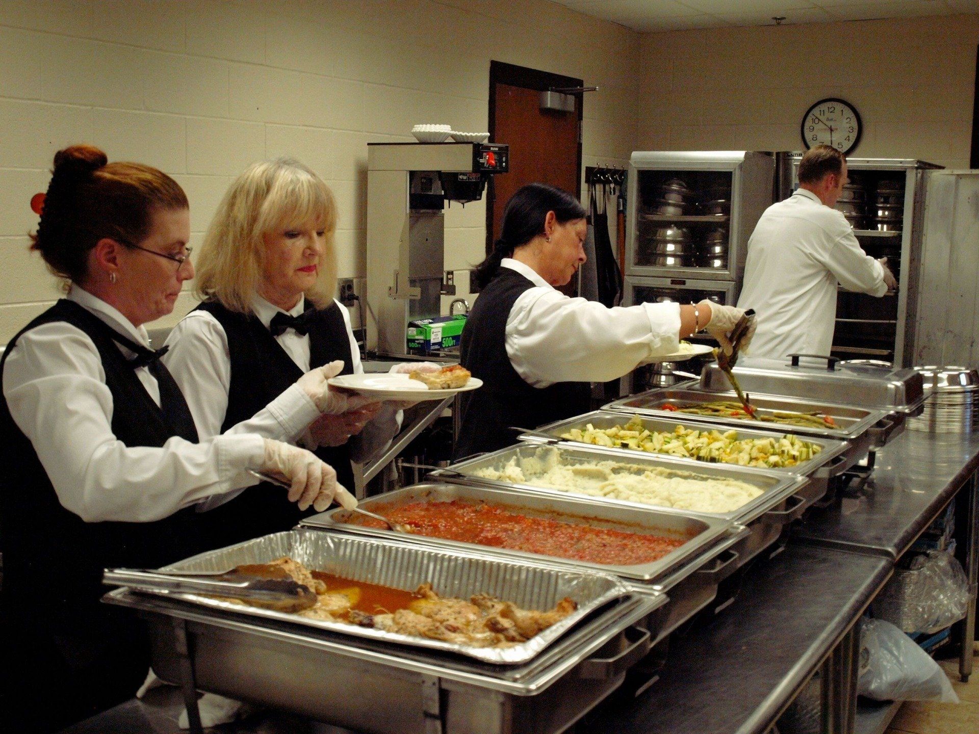 female caterers plating food