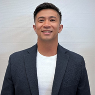 A man in a suit and white shirt is smiling for the camera.