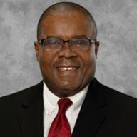 A man in a suit and tie is smiling for the camera.