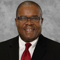 A man in a suit and tie is smiling for the camera.