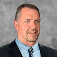 A man in a suit and tie is smiling for the camera.