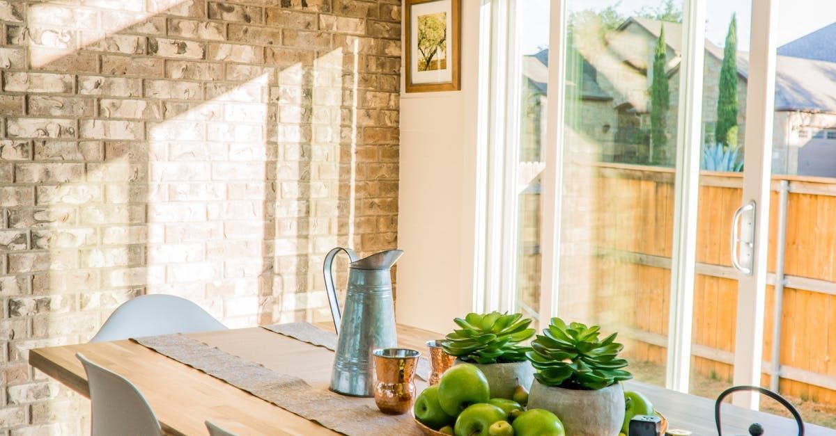 A dining room with a table and chairs and a sliding glass door.