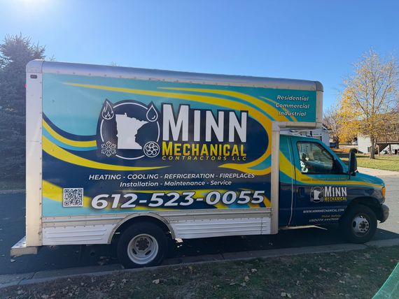 A blue and white Minn Mechanical service truck parked on a street.