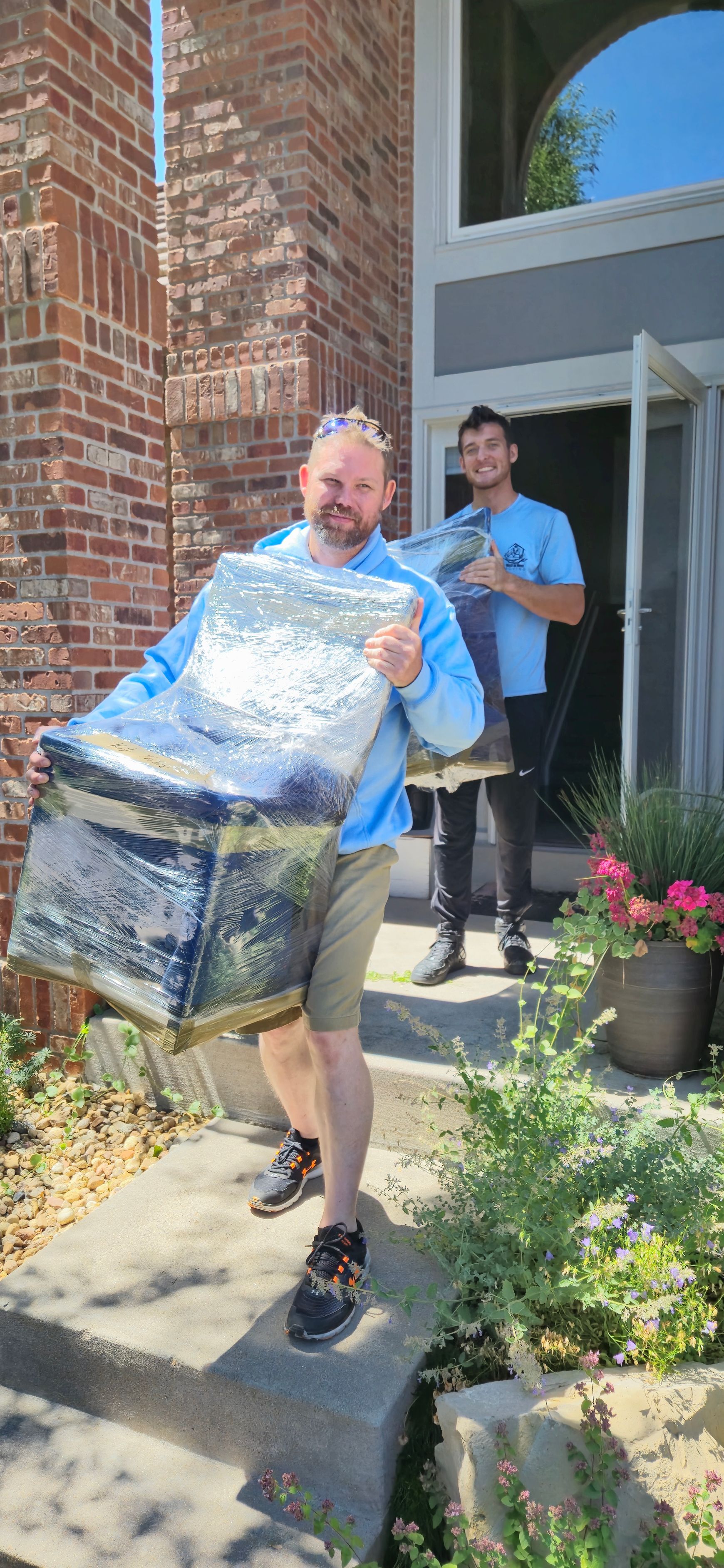 A man is standing in front of a blue truck with a chicken on the side.