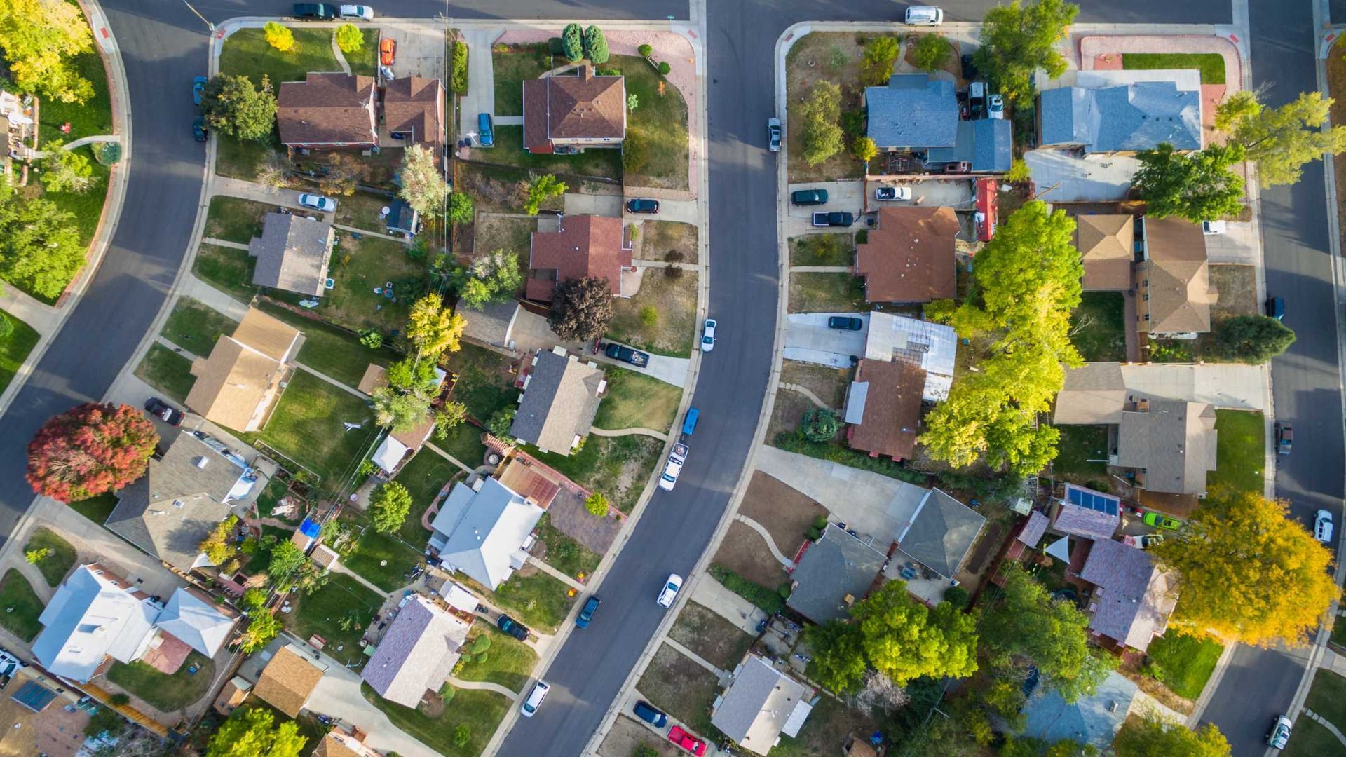 An aerial view of a residential neighborhood with lots of houses and trees.