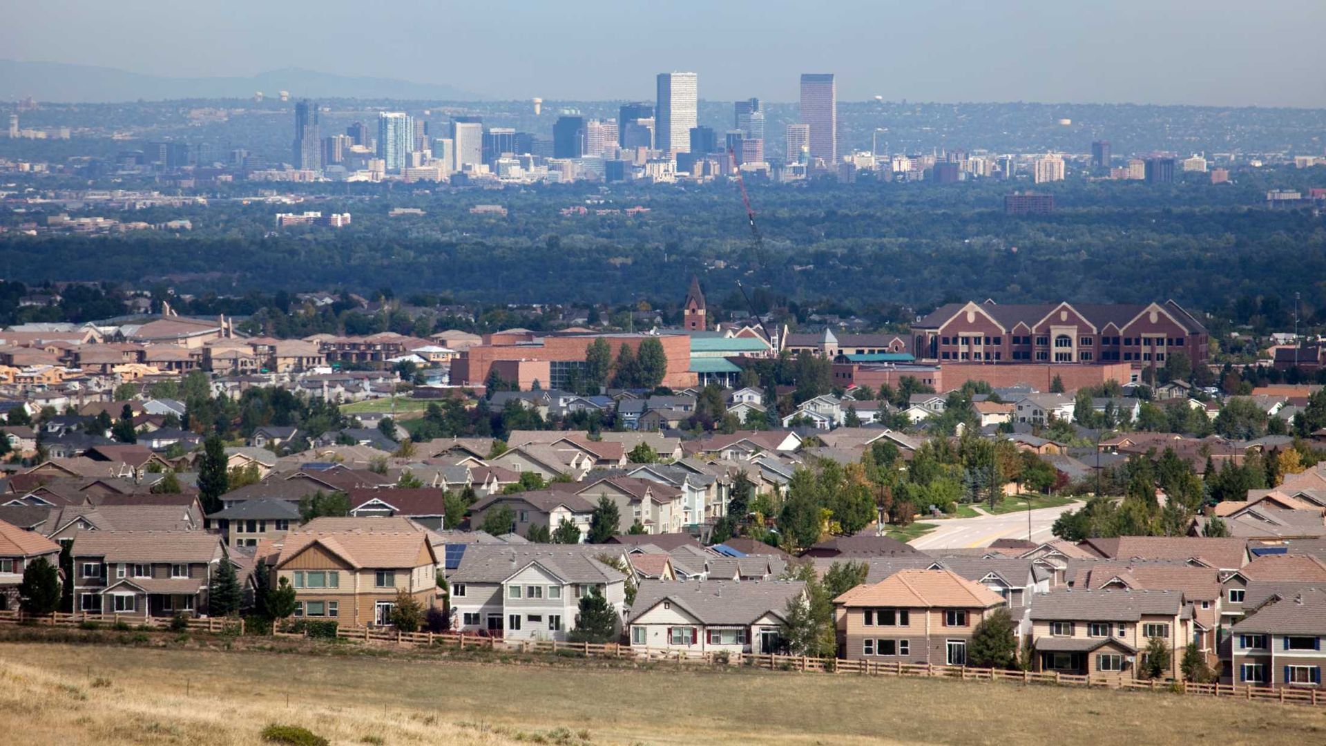 An aerial view of a residential area with a city skyline in the background.