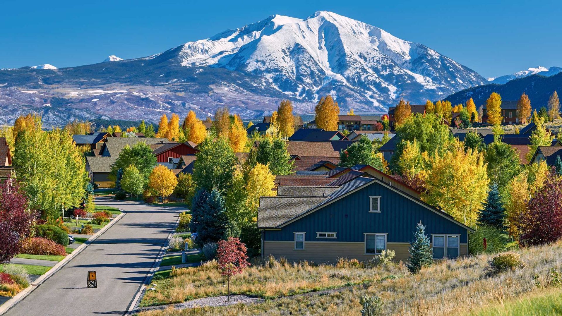A house in a residential area with a mountain in the background.