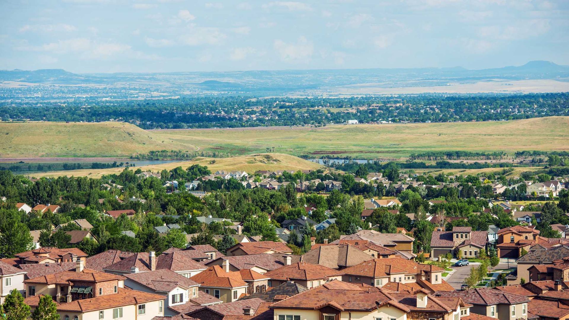 An aerial view of a residential area with a river in the background.