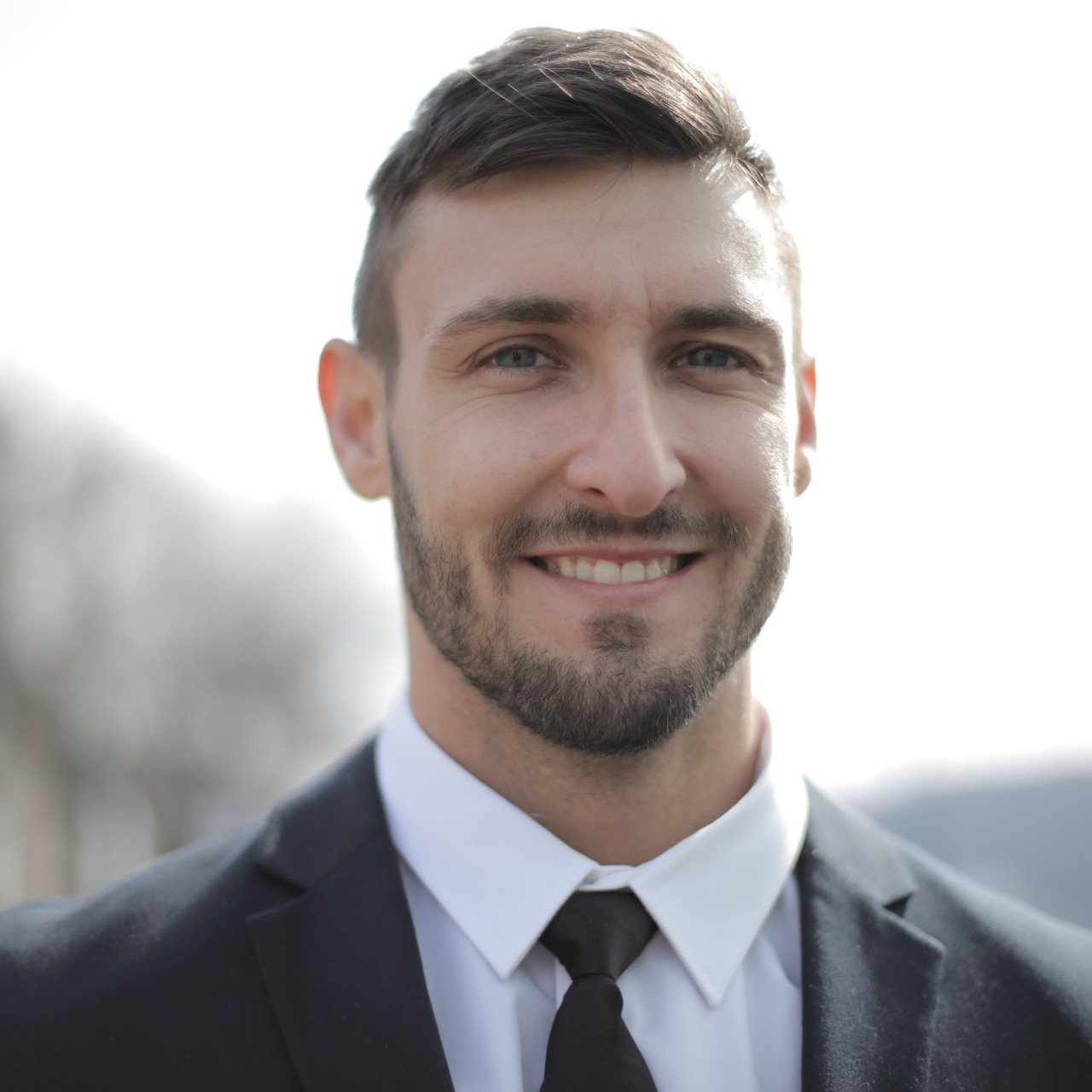 A man in a suit and tie is smiling for the camera.