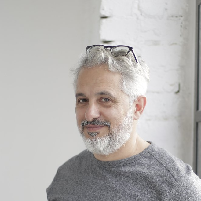 A man with a beard and glasses is smiling for the camera.