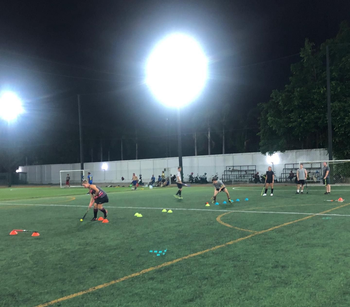 A group of people are playing soccer on a field at night.