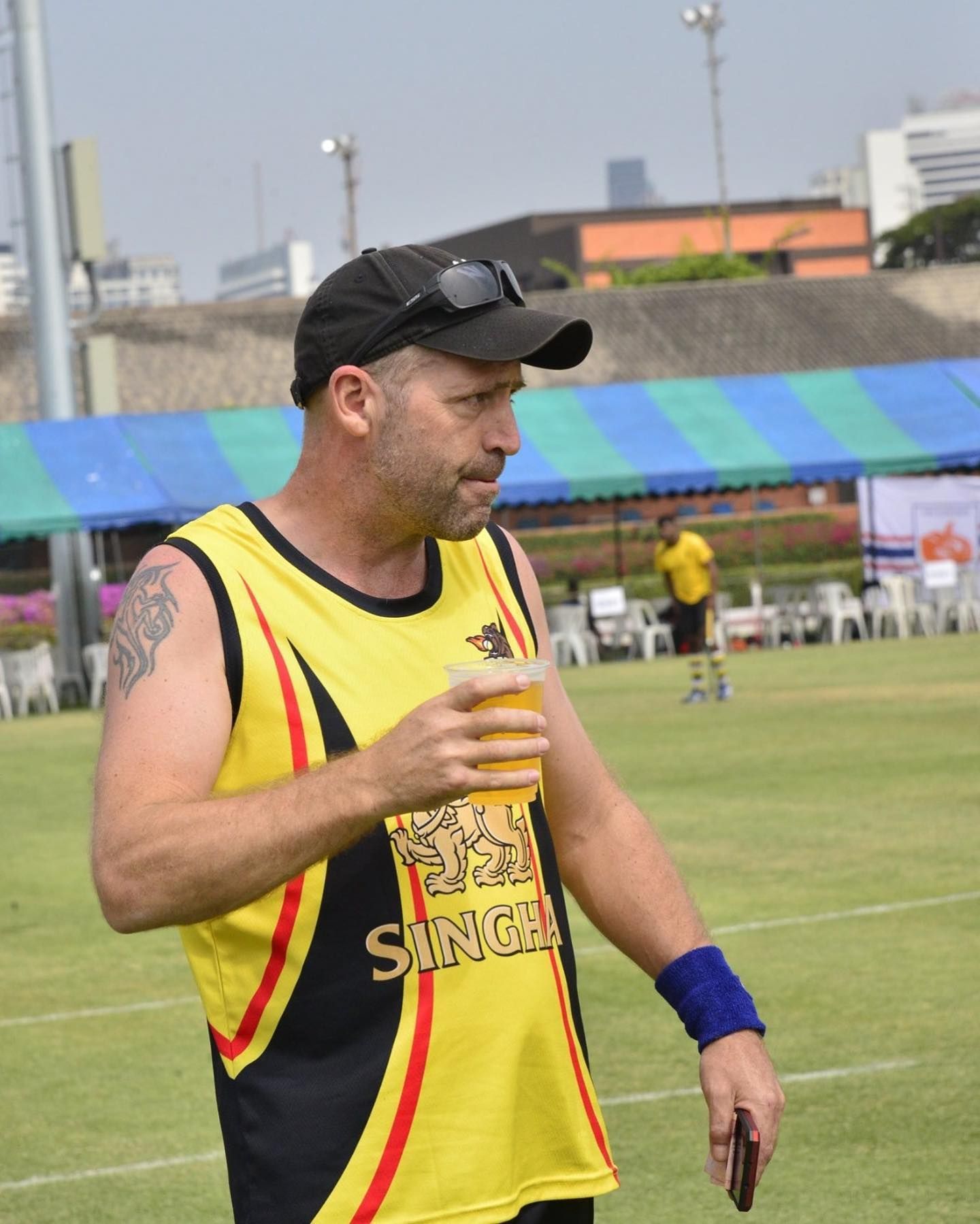A man wearing a yellow shirt with the word sangha on it