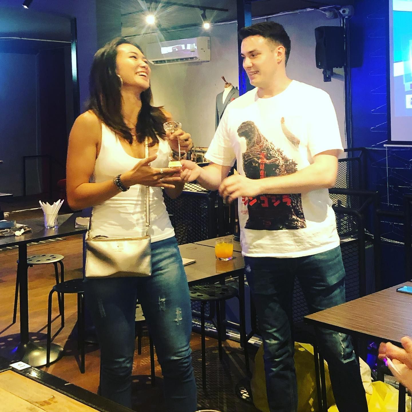 A man and a woman are standing next to each other in a restaurant