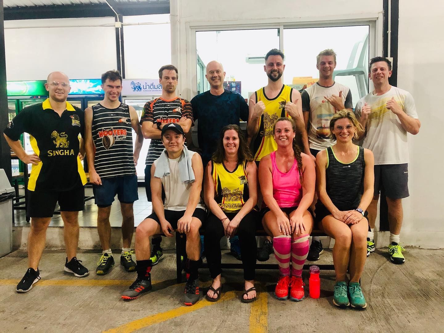 A group of people are posing for a picture in a parking lot.