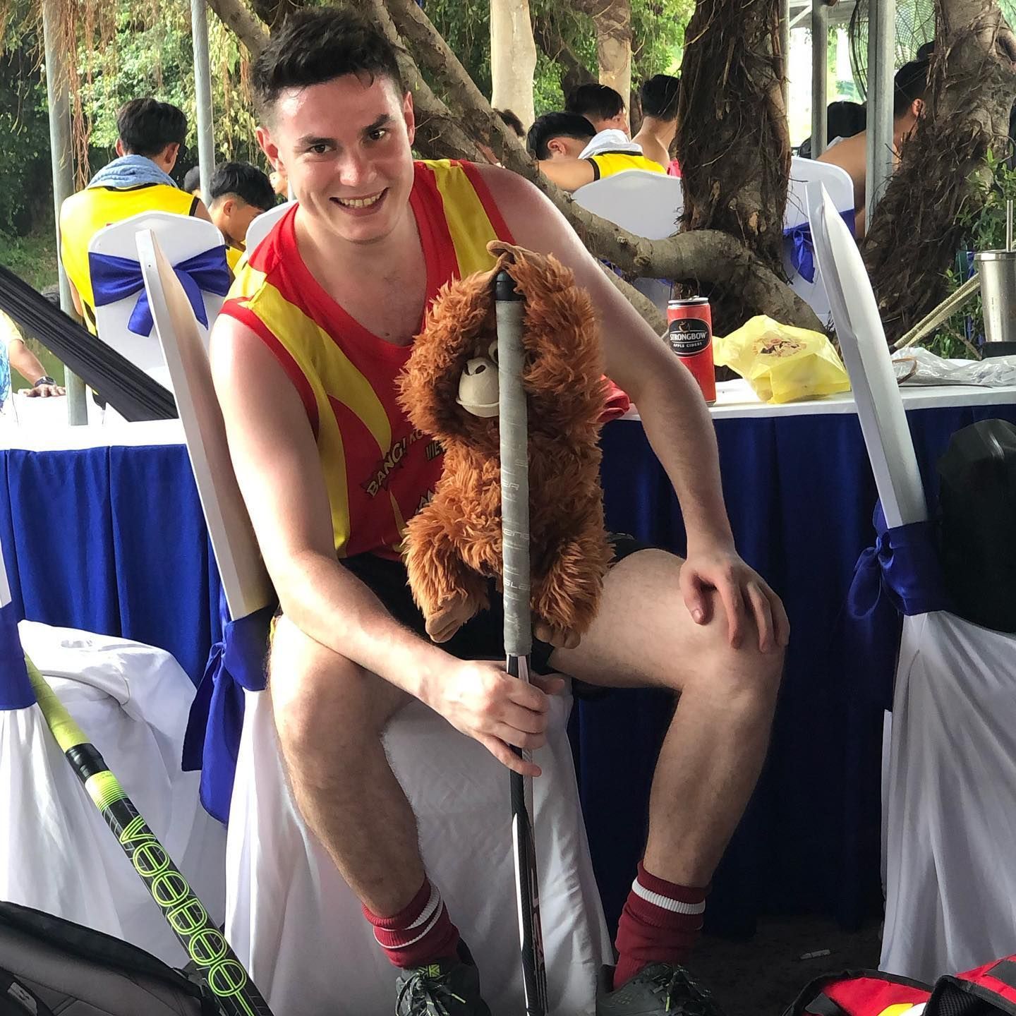 A man is sitting on a chair with a stuffed animal on his lap