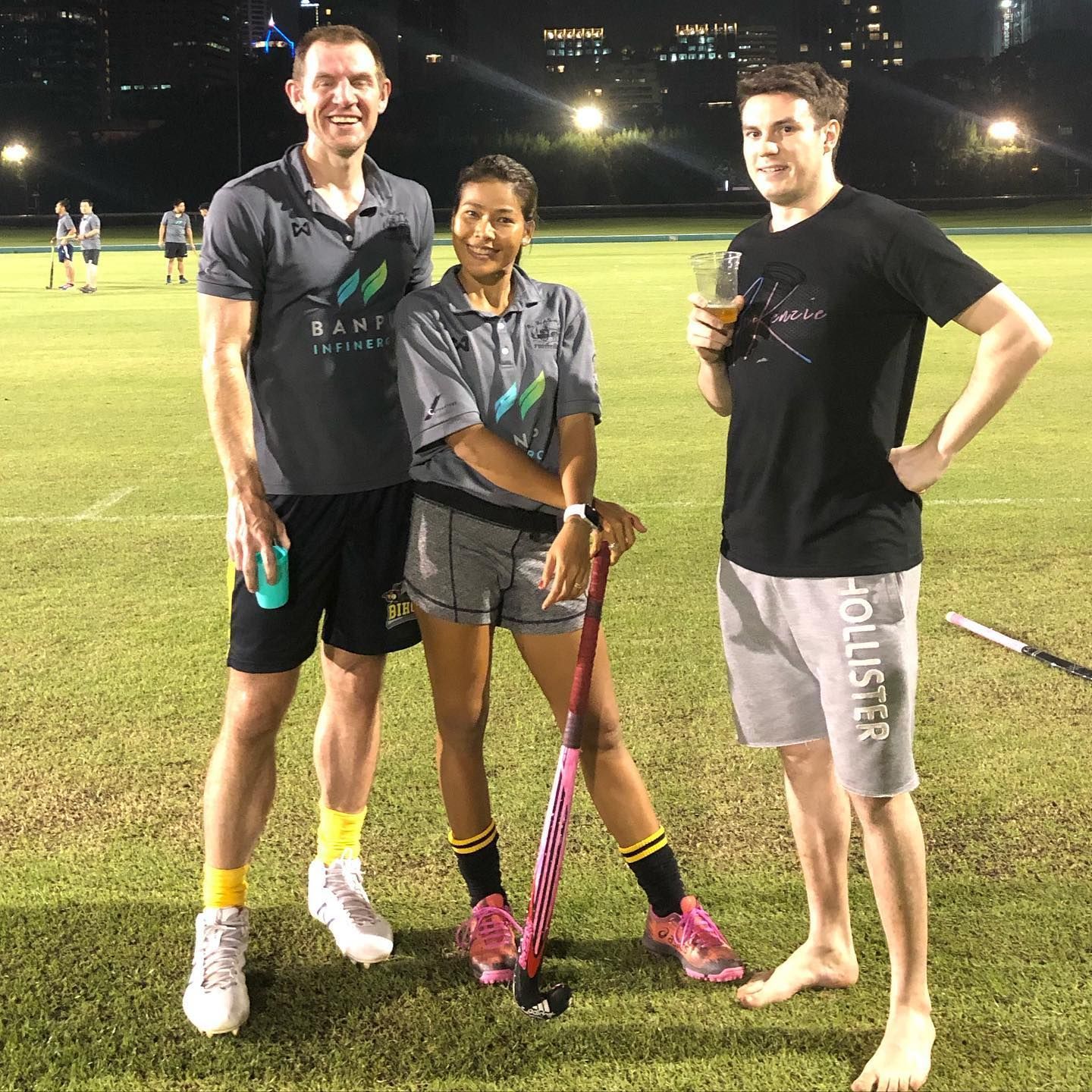 Three people standing on a field with hollister shorts on