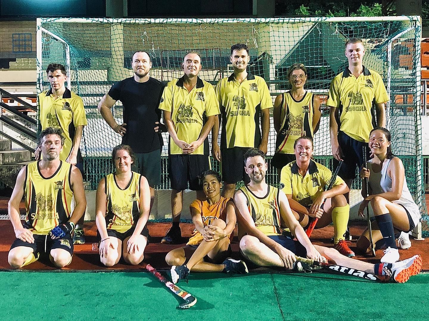 A group of people are posing for a picture on a field.