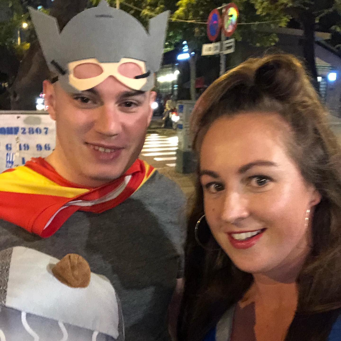 A man in a superhero costume poses with a woman