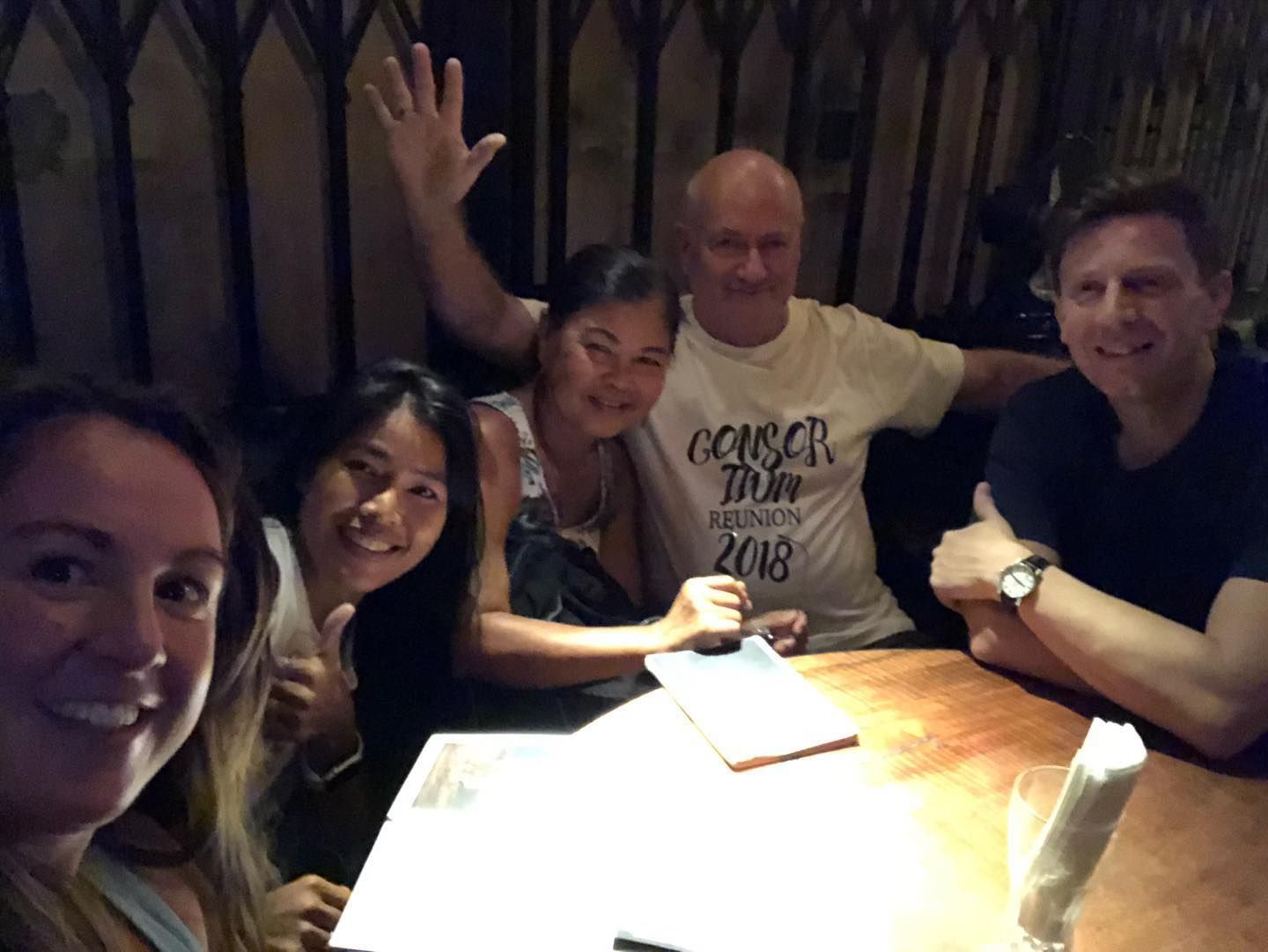 A group of people sitting around a table with one man wearing a corsair shirt