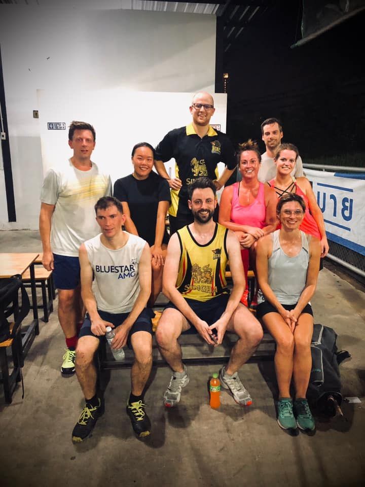 A group of people are posing for a picture in a gym.