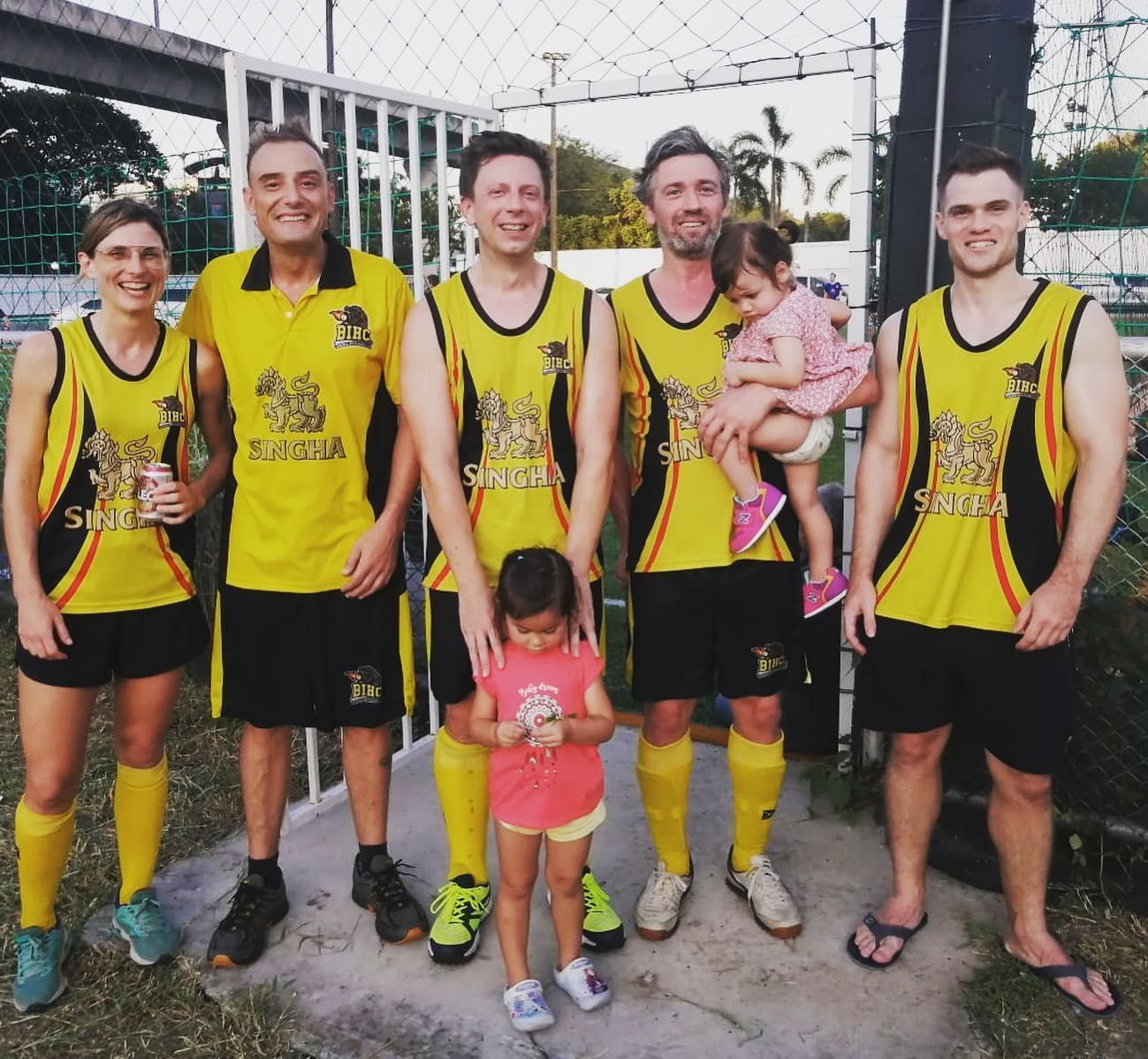 A group of people posing for a picture with one of them holding a child