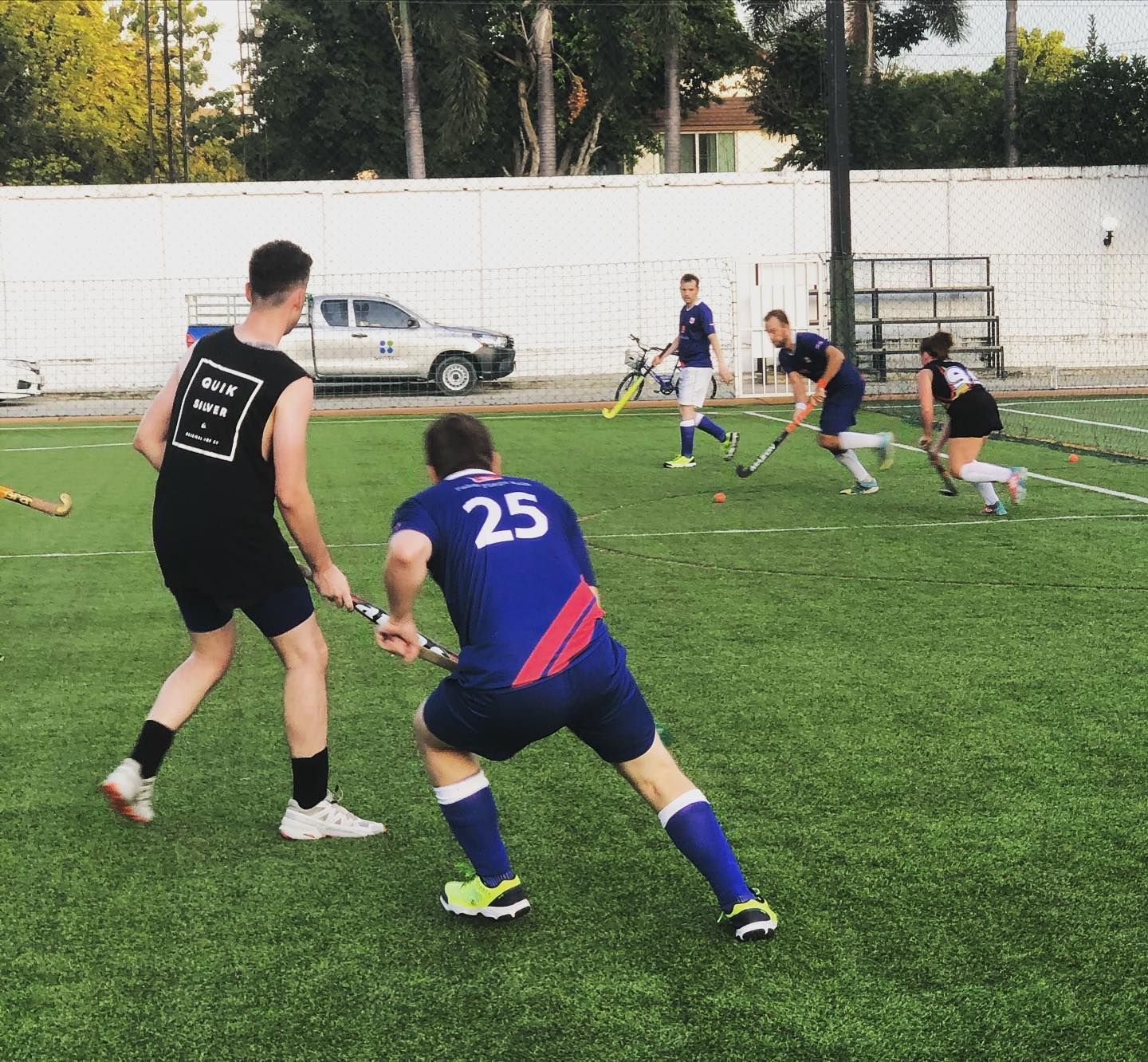A man with the number 25 on his back is playing field hockey