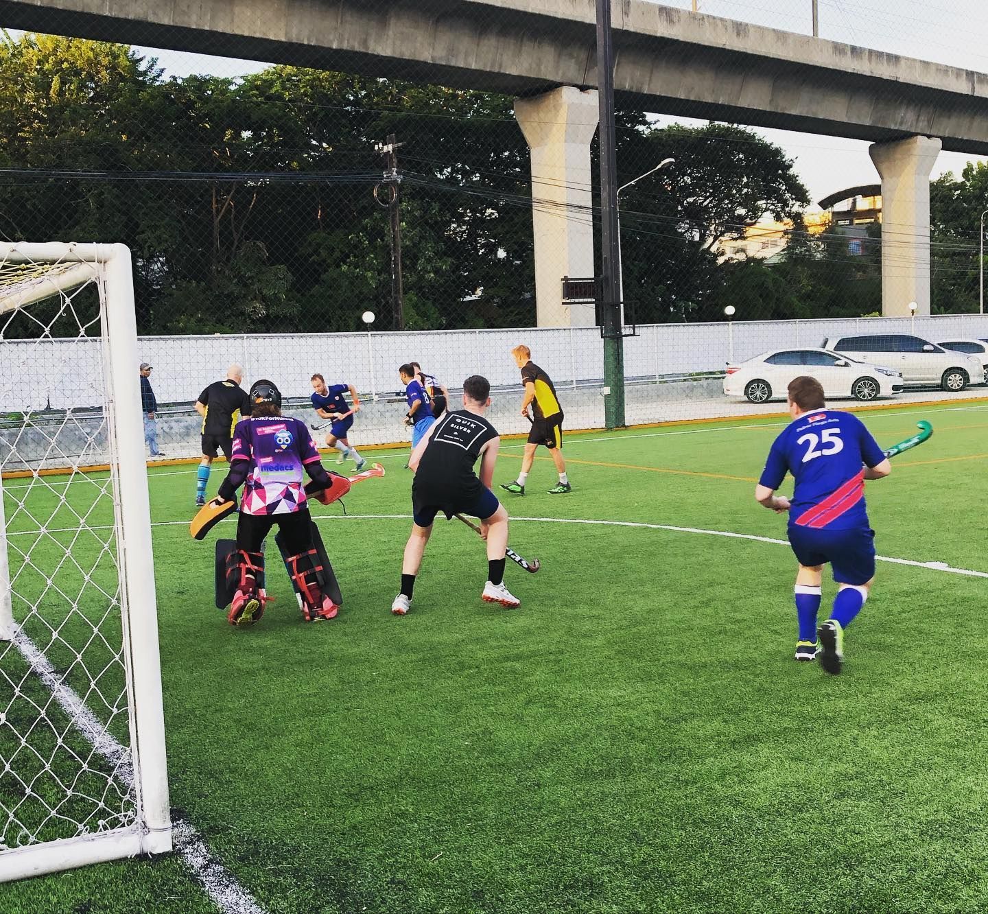 A man with the number 25 on his back is playing field hockey