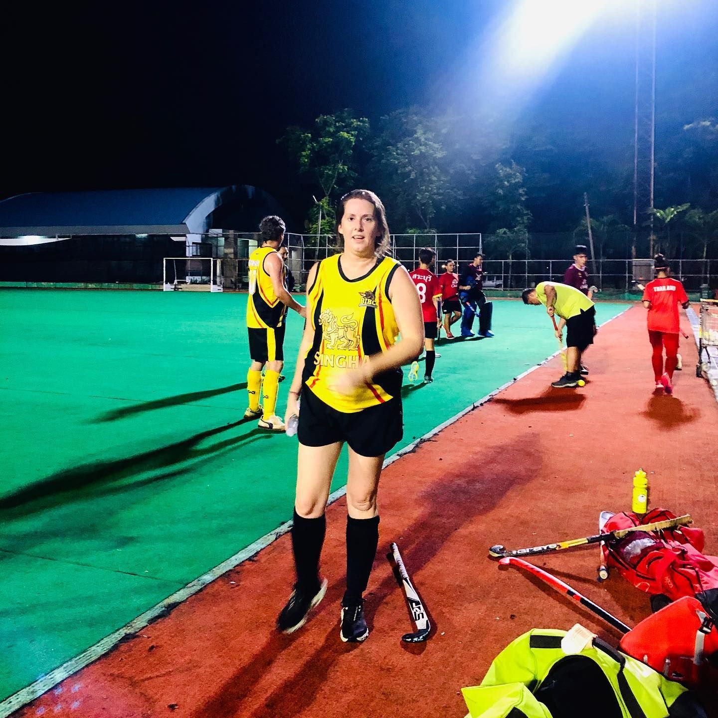 A woman is standing on a field holding a hockey stick