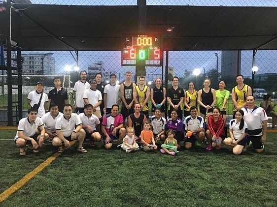 A group of people are posing for a picture on a soccer field.