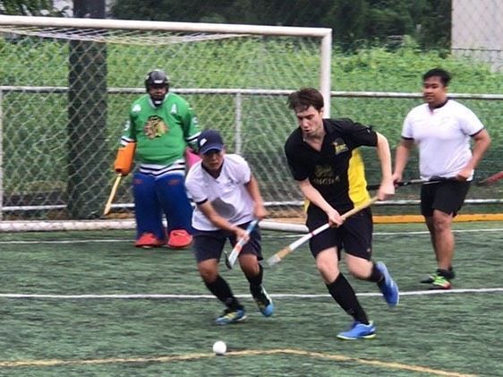 A group of young men are playing a game of field hockey