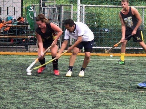 A group of people are playing a game of field hockey