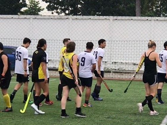 A group of people are playing a game of field hockey