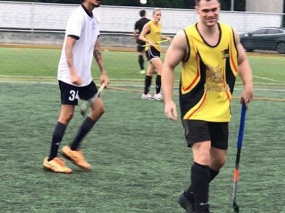 A man with the number 34 on his shorts is holding a hockey stick