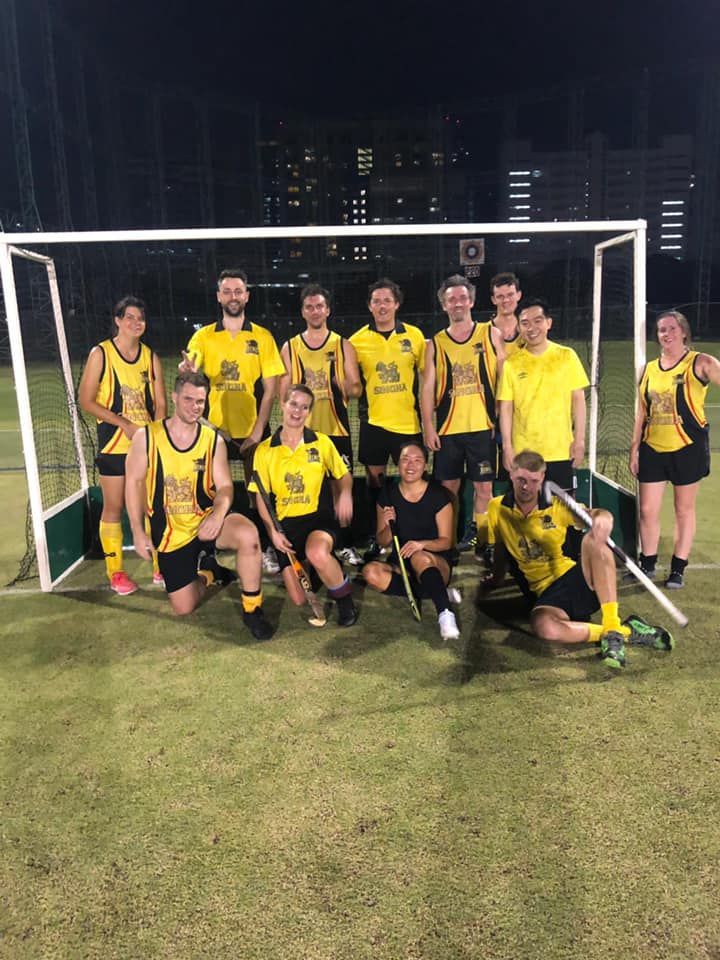 A group of people are posing for a picture in front of a soccer goal.